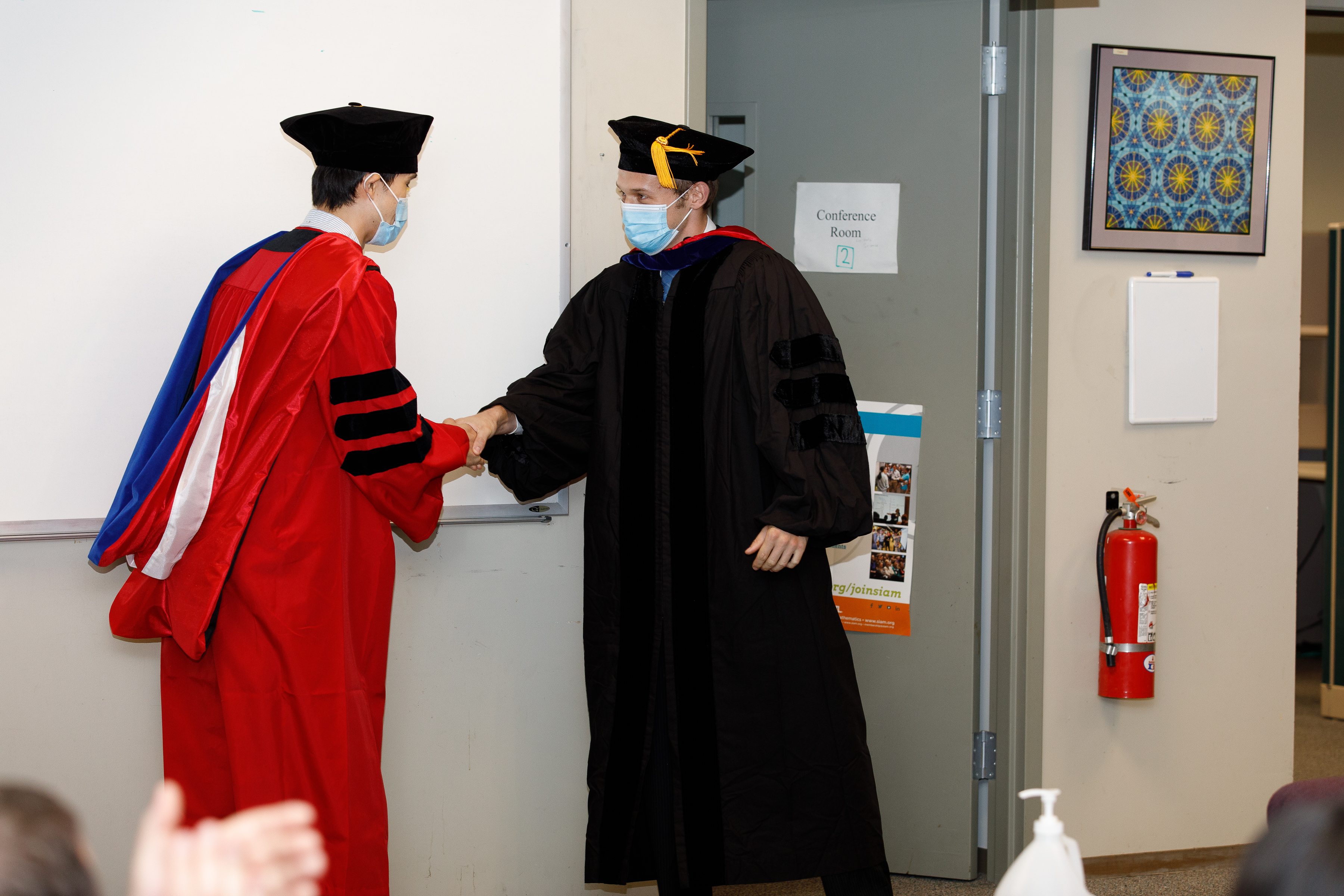 Alex Townsend shaking hands with Tianyi Shi at graduation